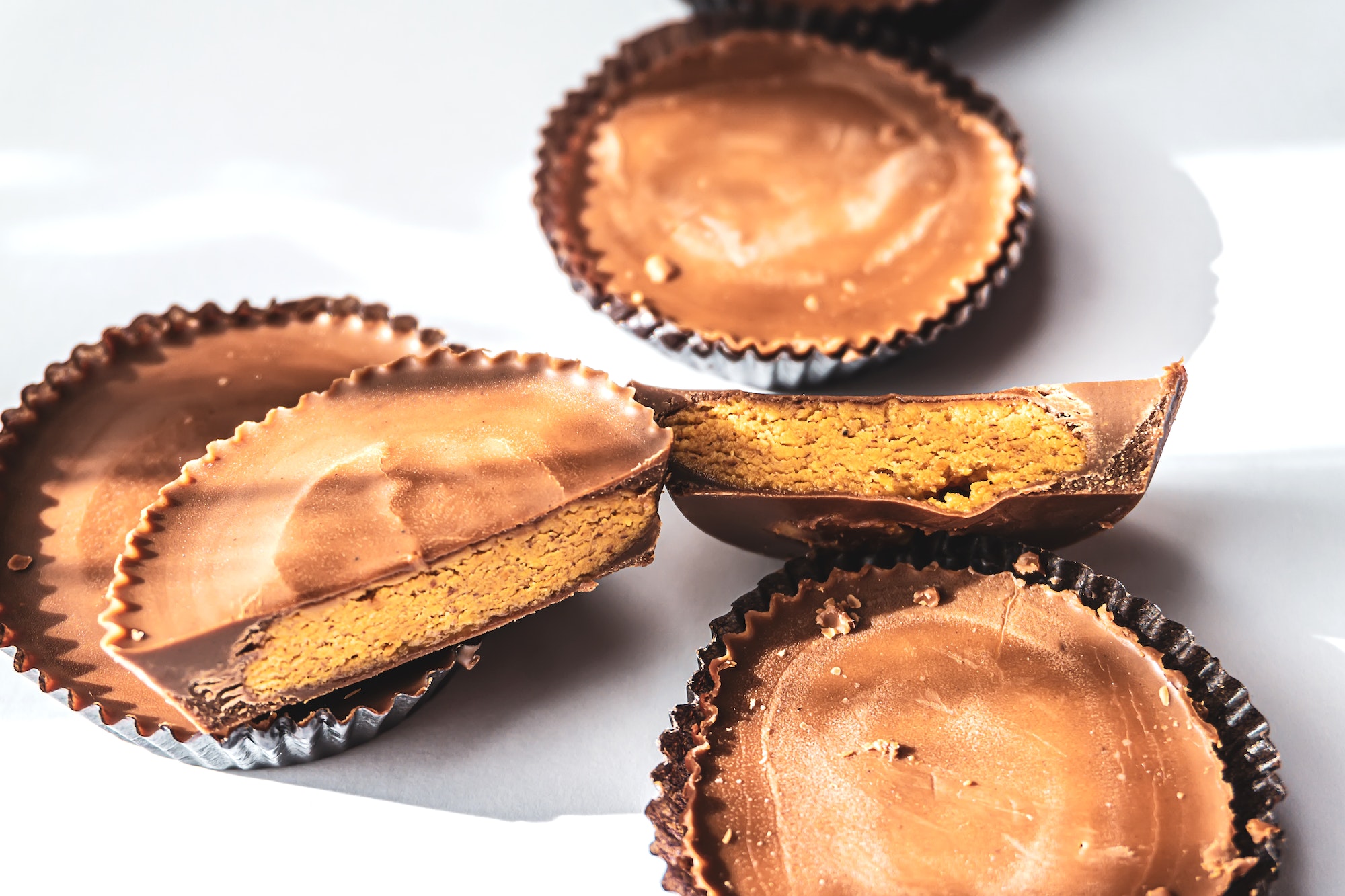 Close up of Peanut butter cups on white background and hard shadows trendy food style photography